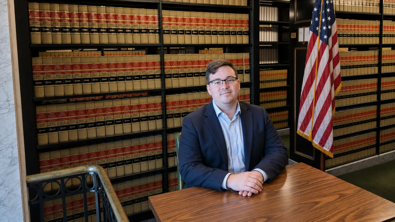 Kevin Duke in a professional setting with the United States flag