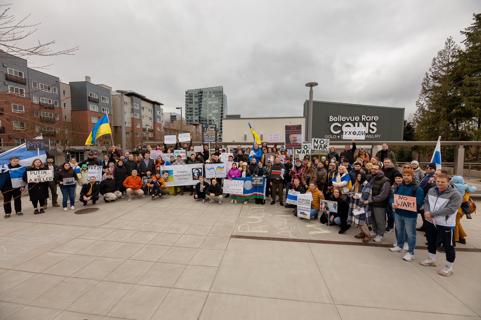 Участники митинга в поддержку Украины с украинскими флагами и антивоенными плакатами в Белвью, штат Вашингтон